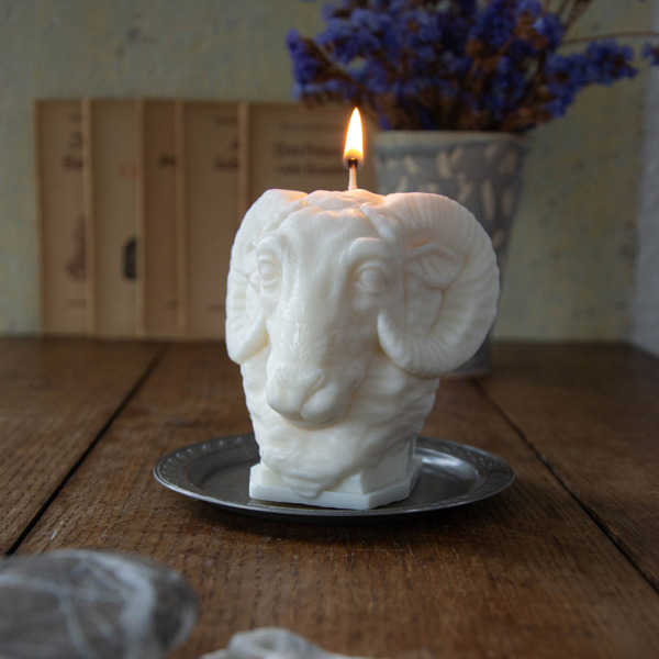 Kerze Widder angezündet, Skulpturkerze Widder, Geschenkkerze Widder brennt, Brennende Formkerze